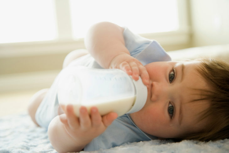 Baby drinking formula from a bottle.