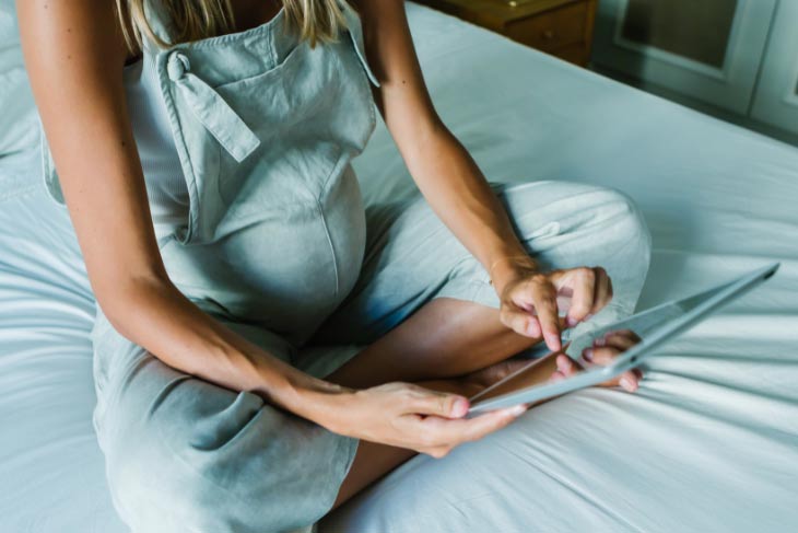 A pregnant woman shopping for prenatal vitamins online.